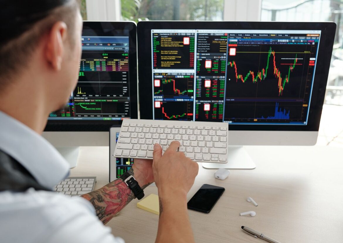 Un trader concentré gère des positions sur de multiples écrans pour l'option trading.