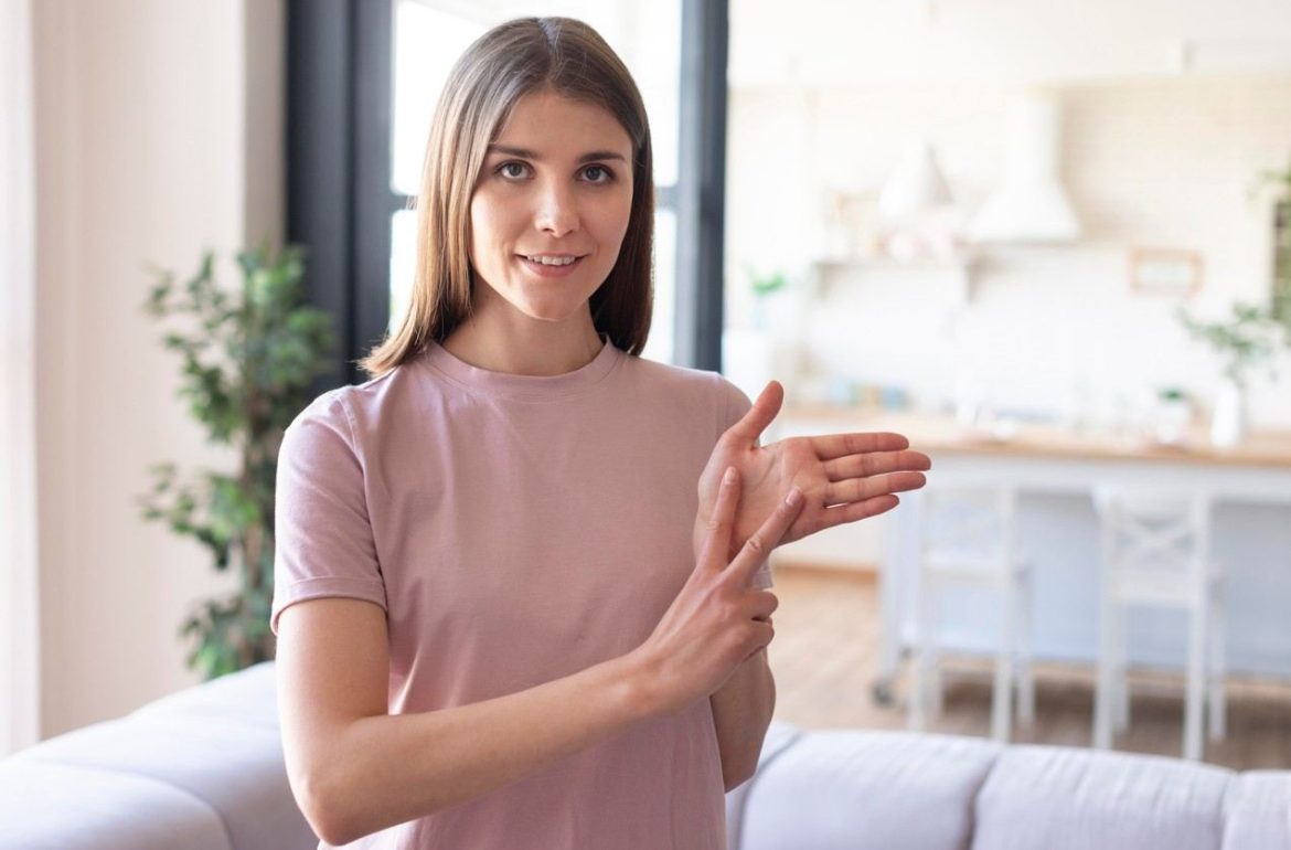 Une femme réalise un massage réflexologique de la main pour calmer l'anxiété en stimulant le bord de sa paume.