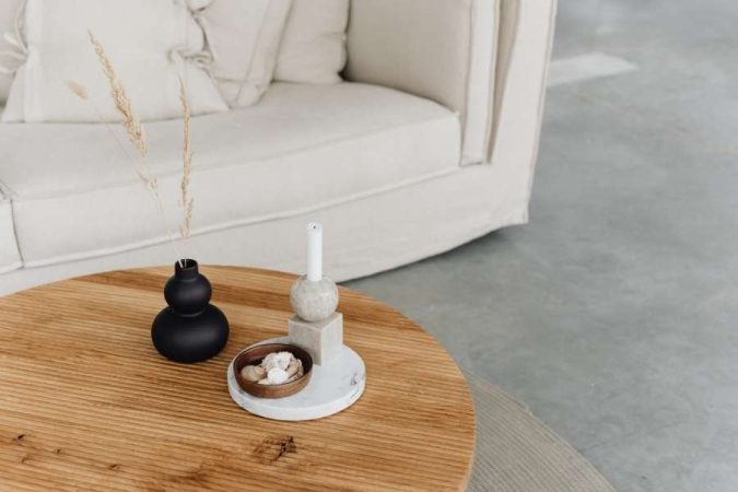 Une table basse ronde en bois naturel met en valeur un meuble ciré élégant dans un salon moderne.